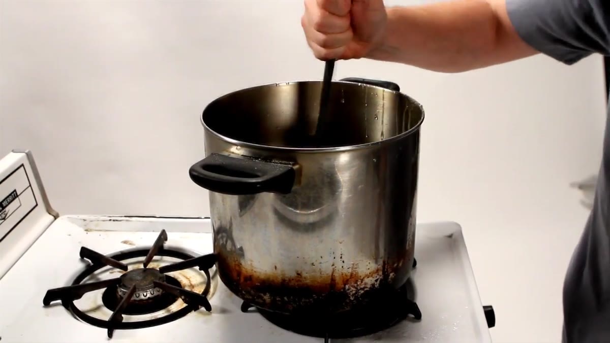 Mixture boiling in pot with thermometer visible