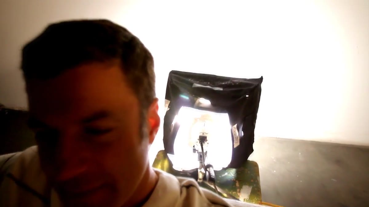 500W light in small softbox pointed and tilted toward wall behind couch