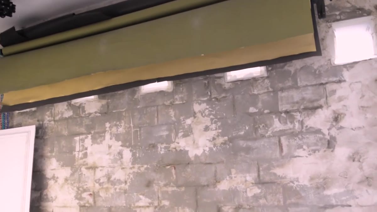 Multiple paper and hand-painted backdrops rolled and stored above shooting area