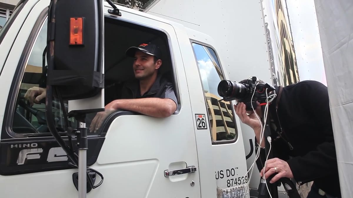 Driver photographed in truck mirror with same left-side strobe position