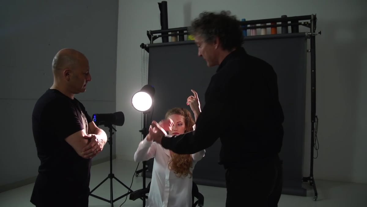 Model raising one arm to direct light toward camera
