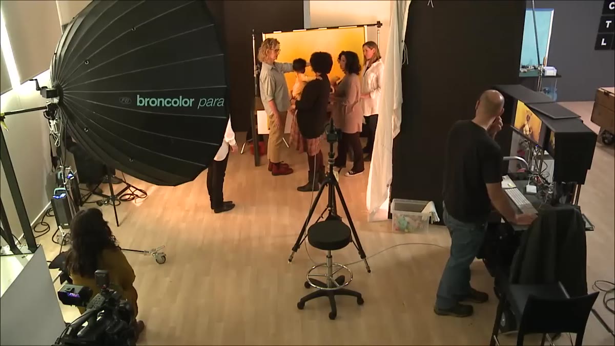 Support person positioned beside infant just outside camera frame
