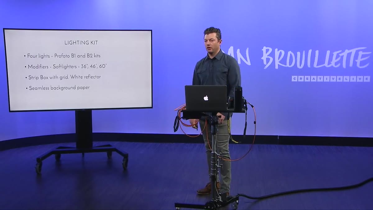 Photographer explaining C-stand and arm setup for 48-inch paper roll