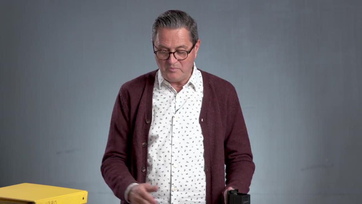 JP flipping through multiple documentation books stored on shelves